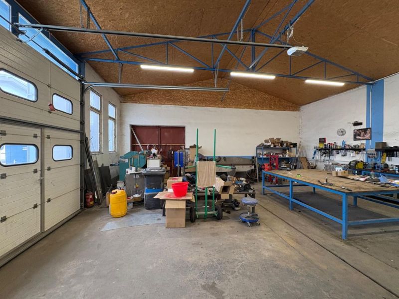 Interior of warehouses and halls with workbenches, tools, and stored materials.