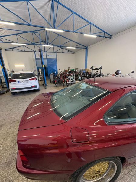 Red car and motorcycles in the workshop Warehouses and halls with a car in the background.