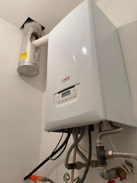 Gas boiler with a piping system on the wall in warehouses and halls.