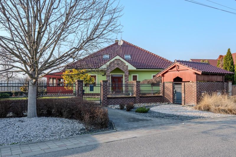A family house in Dolný Bar with a red roof and green facade.