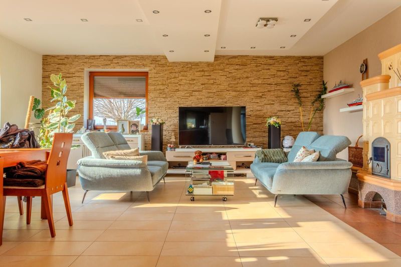 Living room of a family house with a television, stove, and comfortable sofas.