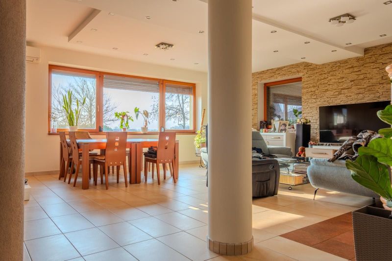 A living room in a family house with large windows and comfortable furniture.