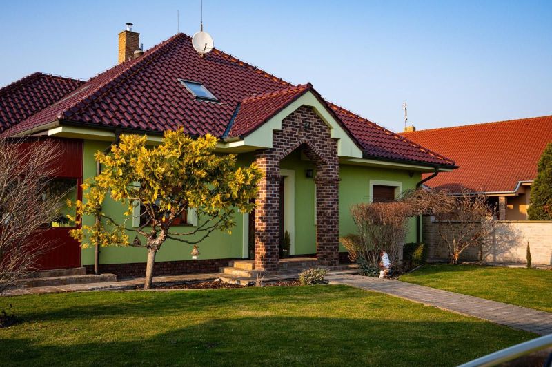 A family house in Dolný Bar with a sloped roof and a landscaped garden.