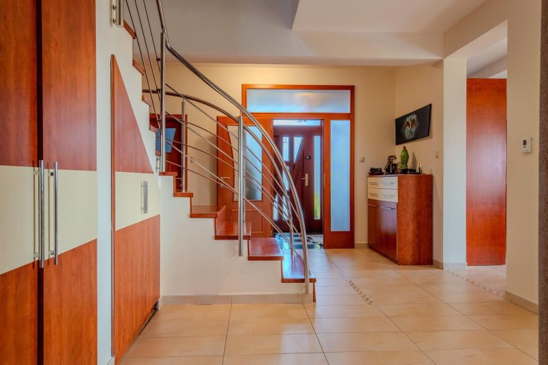 Staircase with railing in the interior of a family house with ceramic flooring.