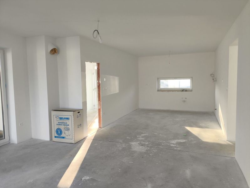 A spacious room with a gray floor and white walls in a family house.
