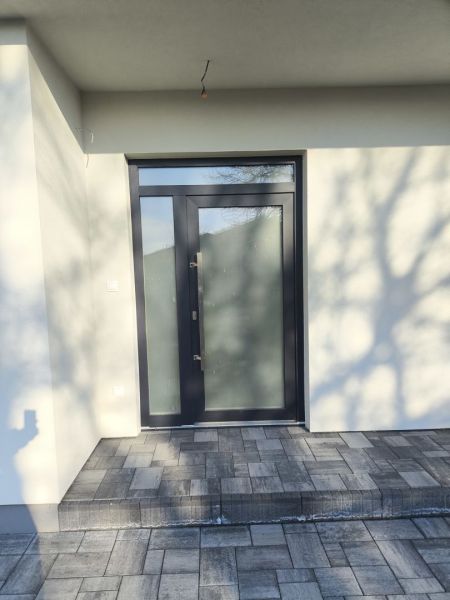 The front door of a family house in Michal na Ostrove with a stone walkway.