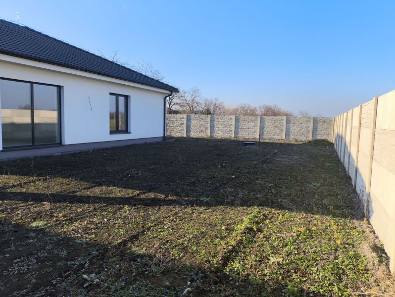 A family house in Michal na Ostrove with a garden and a stone fence at the back.