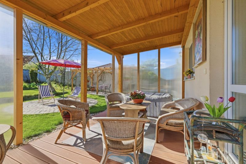 Terrace of a family house in Kostolné Kračany with rattan furniture and garden seating.