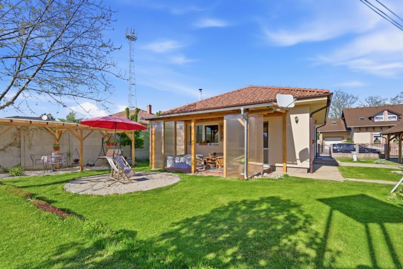 A garden terrace at a family house in Kostolné Kračany with seating and a sunshade.