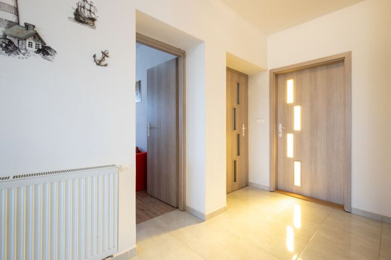 Interior of a family house with a wooden decor floor, central heating, and wall decorations.