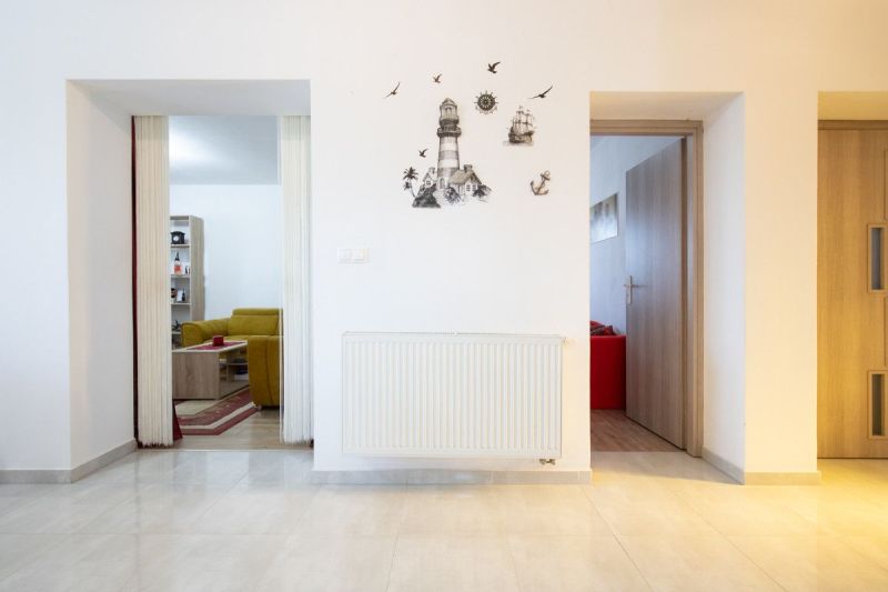Interior of a family house with white walls, wall decoration, and an open entrance to the living room.