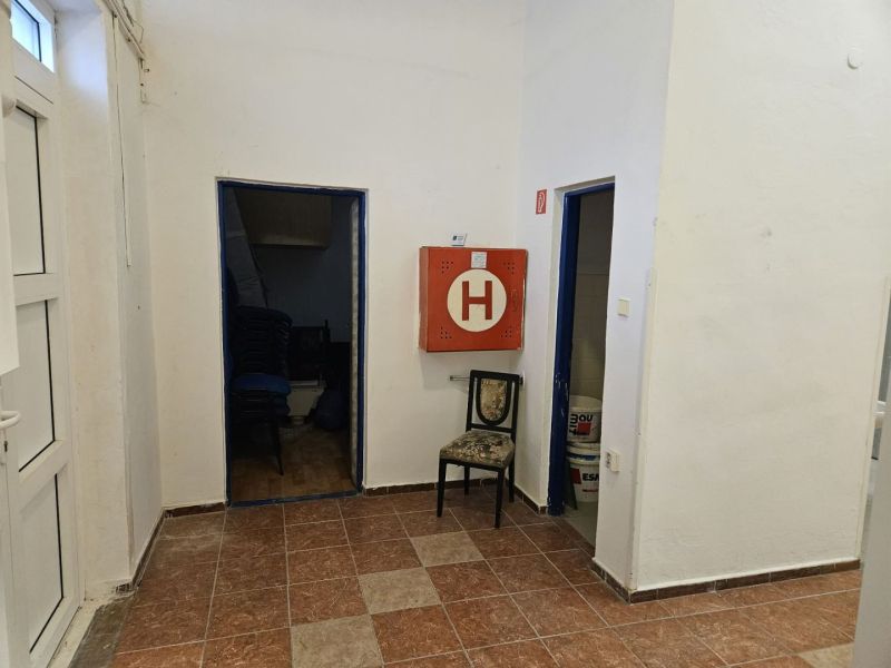 Commercial premises with tiles, folding chairs, and a fire cabinet.