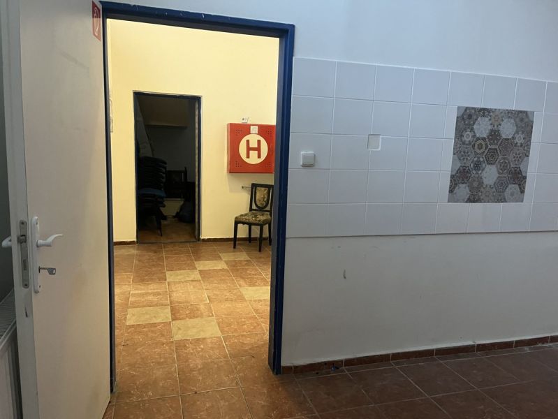 Interior of commercial premises with tiles and tiled floor, open door.