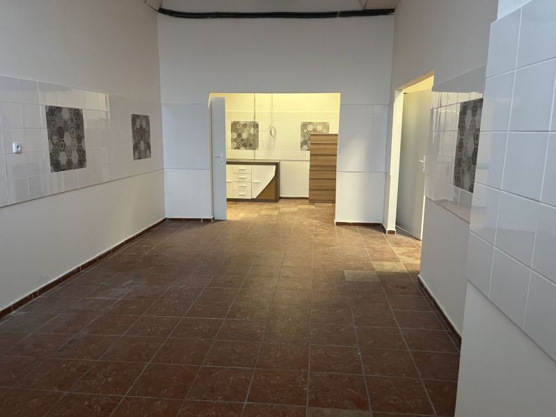 Interior of commercial spaces with tiled floors and decorative tiles on the walls.