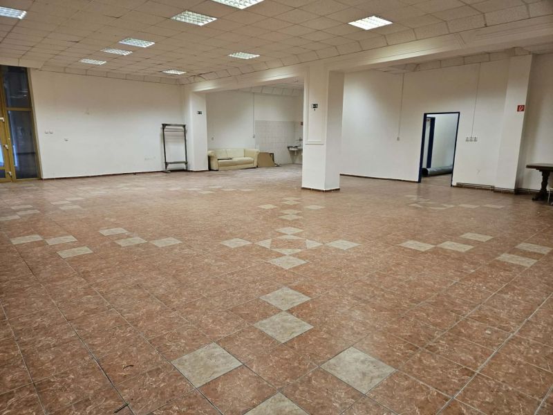 Commercial space with tiled flooring, white walls, and a sofa in the corner of the room.