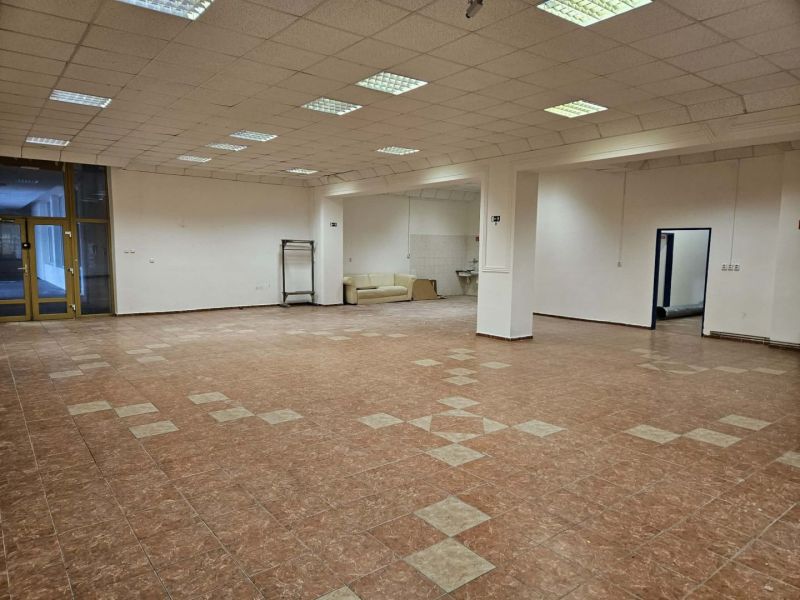Spacious commercial spaces with a tile-patterned floor and white walls.