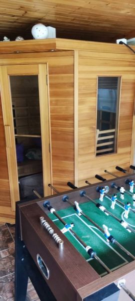 Sauna and table football in a family house with a wooden decor floor.