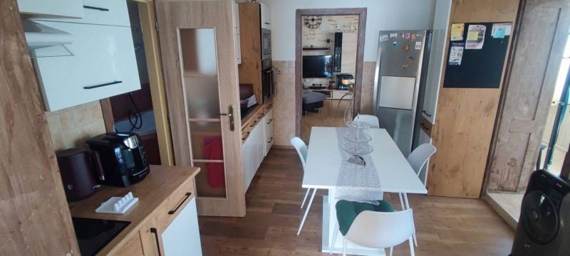 A kitchen in a family house with a wood-patterned floor and modern equipment.