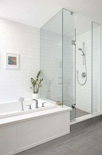 A bathroom in a family house with a bathtub, a shower corner, and tiles in light shades.