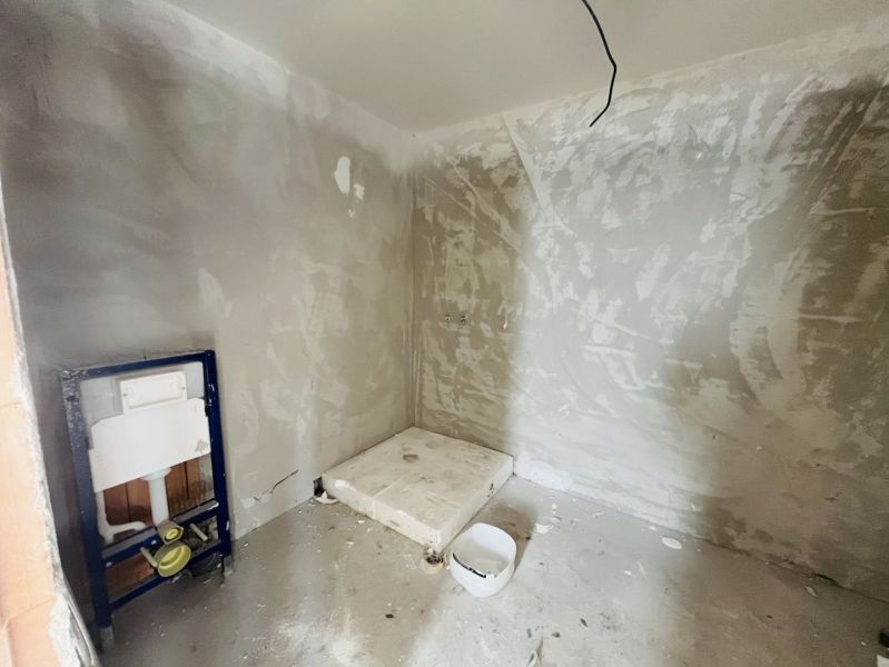 A bathroom under construction in a family house with preparations for sanitary equipment.