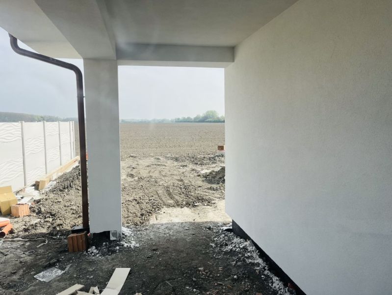 The exterior of a family house in Michal na Ostrove with a view of a plowed field.