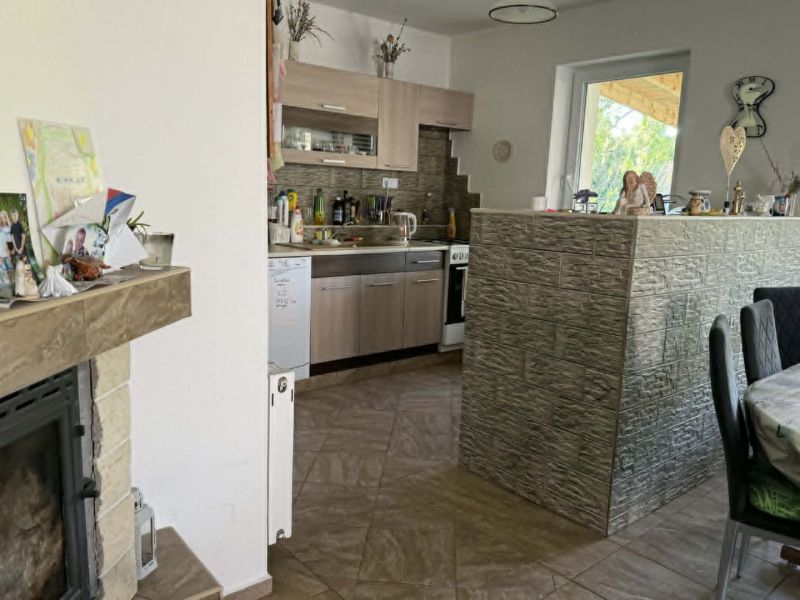 A kitchen in a family house with a brick bar and fireplace, tiled floor.
