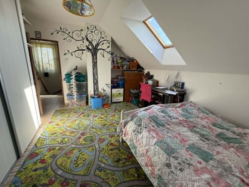 Children's room in a family house with a cheerful carpet and tree decoration on the wall.