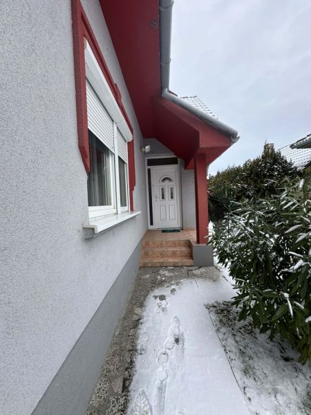 Entrance to a family house in Dolný Štál with white doors and a snow-covered walkway.