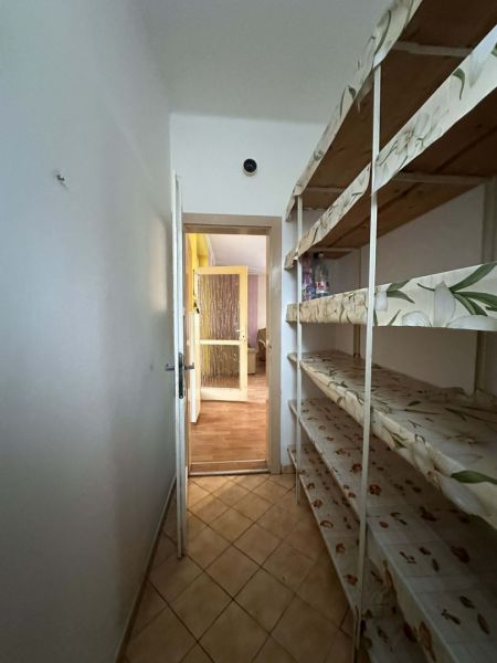 A narrow pantry in a family house with shelves, an open door in the background.