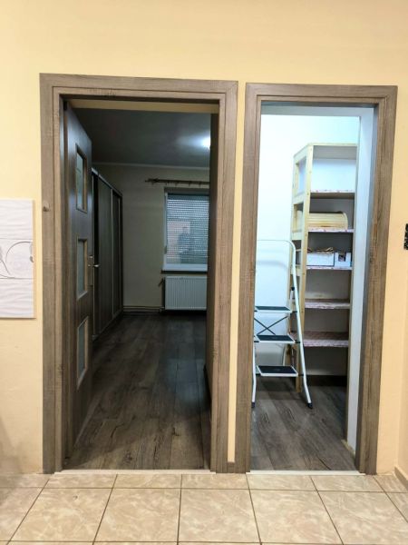 The interior of a family house with a wooden decor floor and open doors.