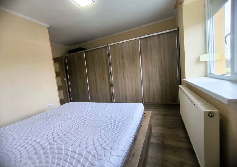 Bedroom in a family house with a sliding wardrobe and a wooden decor floor.
