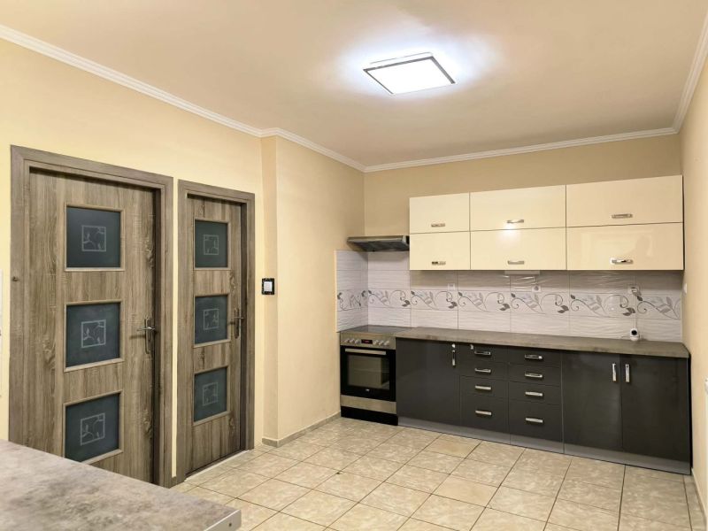 A kitchen in a family house with a tiled floor and a modern kitchen unit.