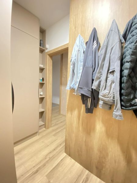 Hallway with coat racks, wooden decor flooring, 3-room apartment.