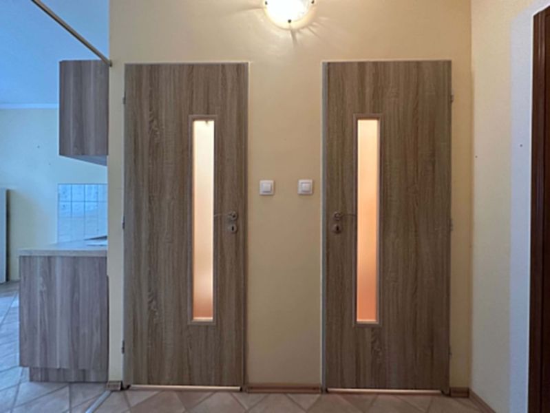 Interior of a one-room apartment with wooden decor doors and tiles.