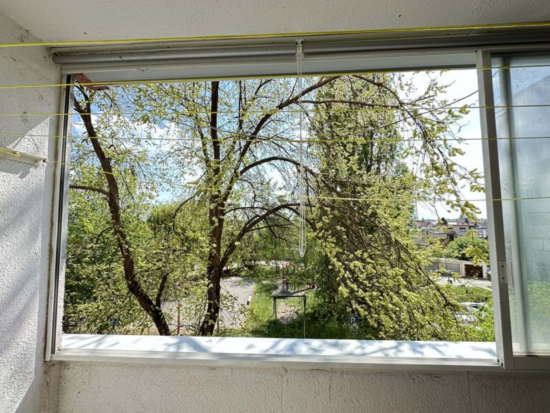 A view from the balcony of a one-room apartment in Dunajská Streda overlooking trees and the city.