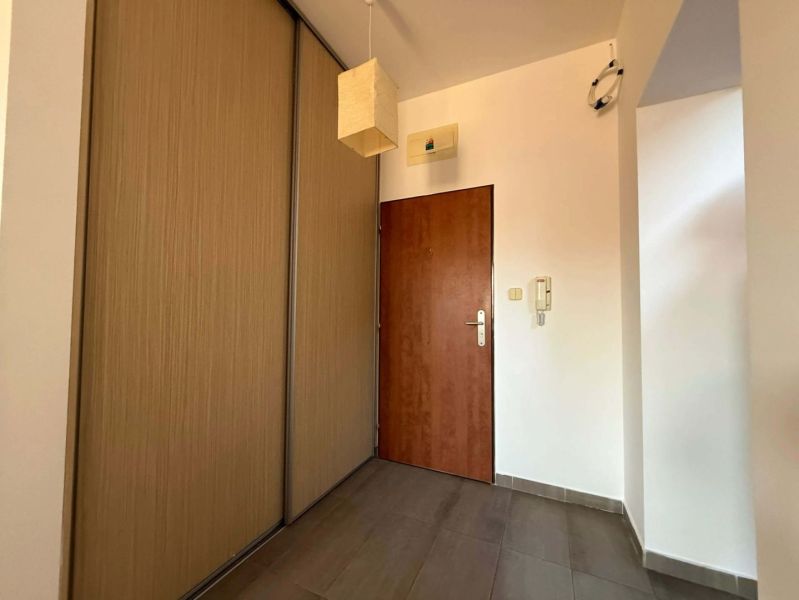 Entrance hallway with a sliding wardrobe and flooring with a wood decor in a 3-room apartment.
