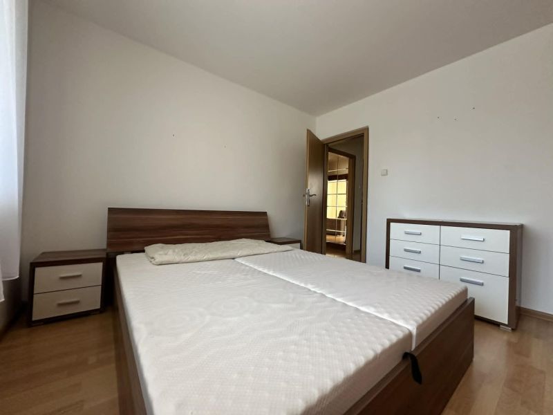Bedroom with a bed, nightstands, and a dresser in a 3-room apartment, floor with wood decor.