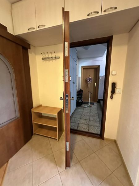 Open entrance door, tiles, wardrobe, and coat rack in a 3-room apartment.