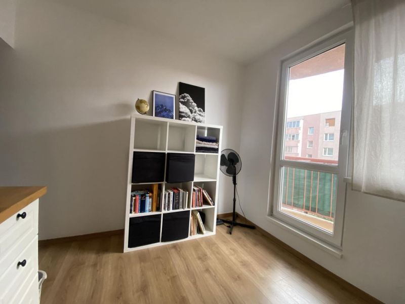 A room in a one-room apartment with a shelving system and a floor with a wood decor.