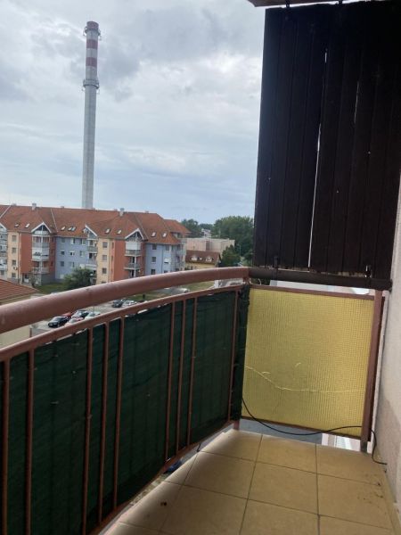 A balcony with a view of apartment buildings and a chimney in Dunajská Streda.