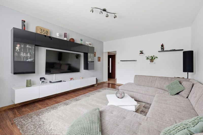 Living room in a 3-room apartment with a corner sofa and a wooden decor floor.