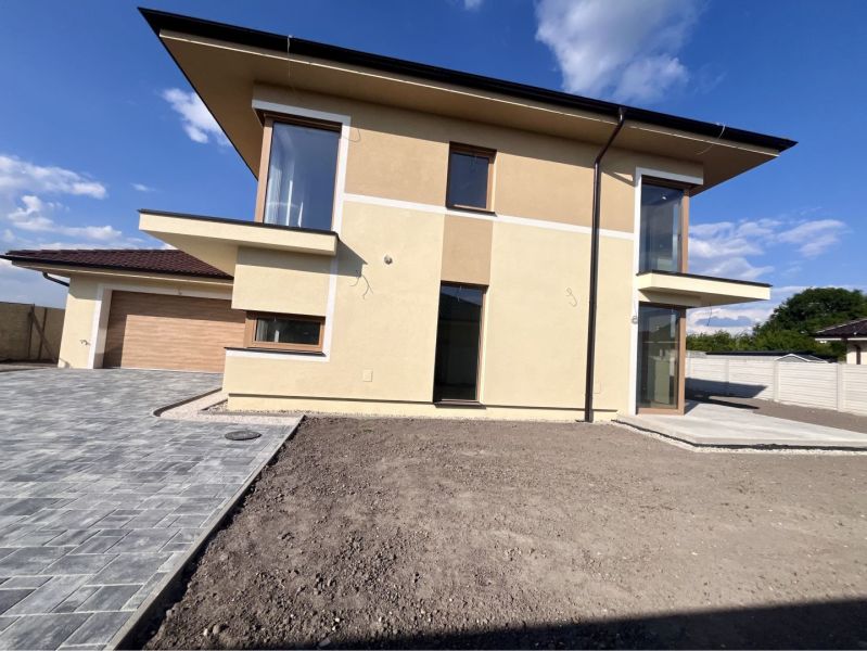 A family house in Dunajská Streda on GARDENTOWN street with a paved parking lot and a garage.