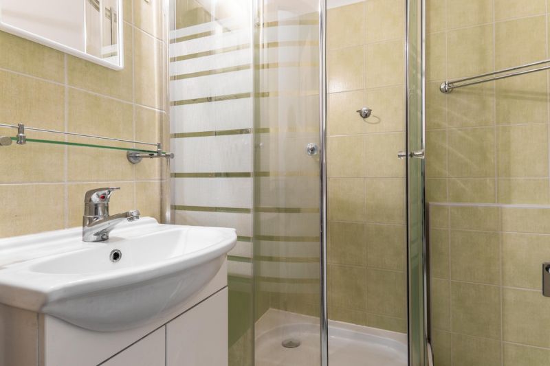 A bathroom in a 3-room apartment with a sink and a shower.