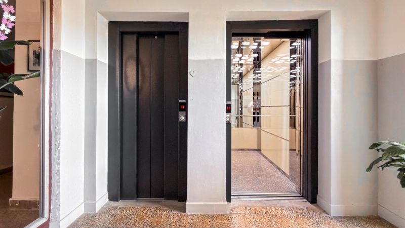 Open elevator doors with reflection of lights, 3-room apartment.