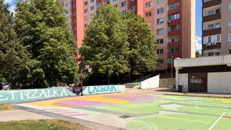 The basketball court on Lachova Street in Bratislava's Petržalka, surrounded by apartment buildings and trees.