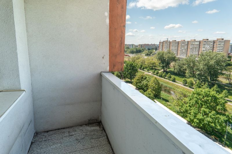 View of greenery and panel buildings from a balcony in Bratislava on Lachova Street.