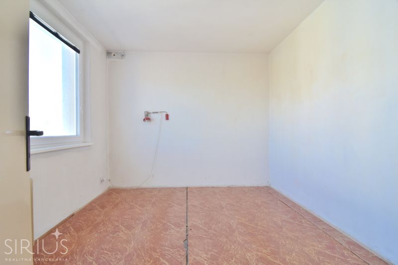 An empty room with a wooden floor in a 3-room apartment.