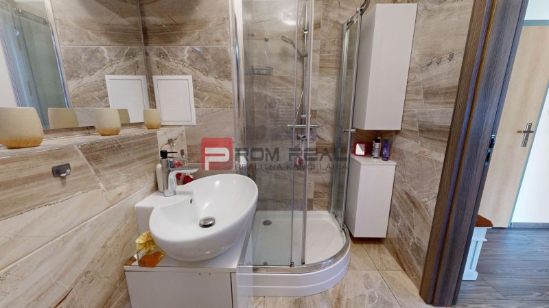A bathroom in a 2-room apartment with a bathtub and a sink, tiled with ceramic tiles.