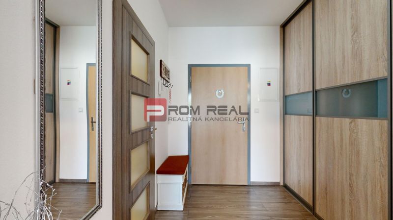 Interior of a 2-room apartment with a wooden decor floor and a built-in wardrobe.