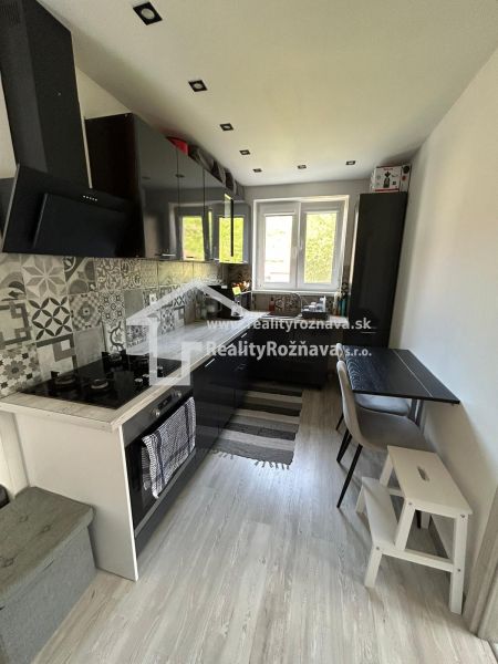 A kitchen with mosaic tiles and a wooden decor floor in a 3-room apartment.
